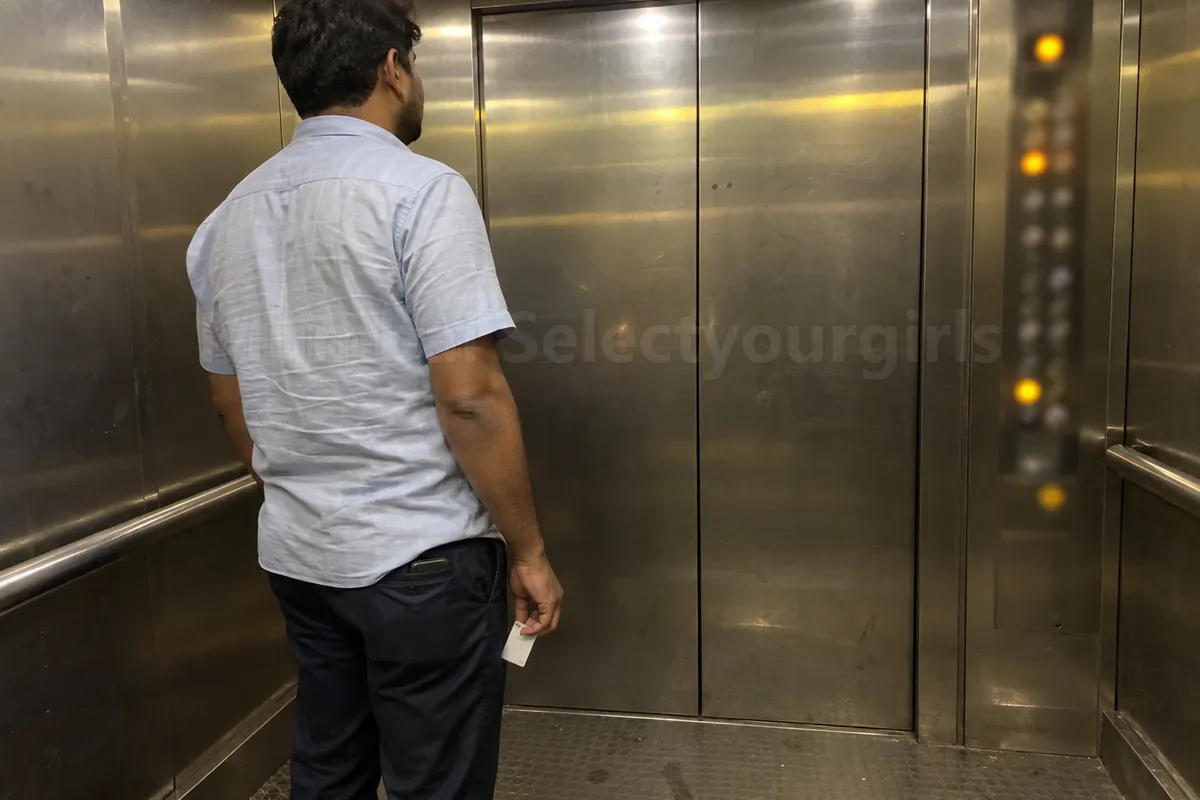 A man with his hotel room key in a hotel lift in Mumbai